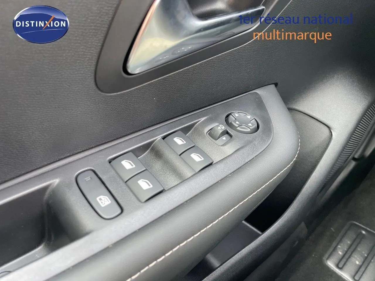 Gros plan sur la commande des vitres côté conducteur de la Peugeot 208 1.2 PureTech jaune Agueda métal, intérieur noir.