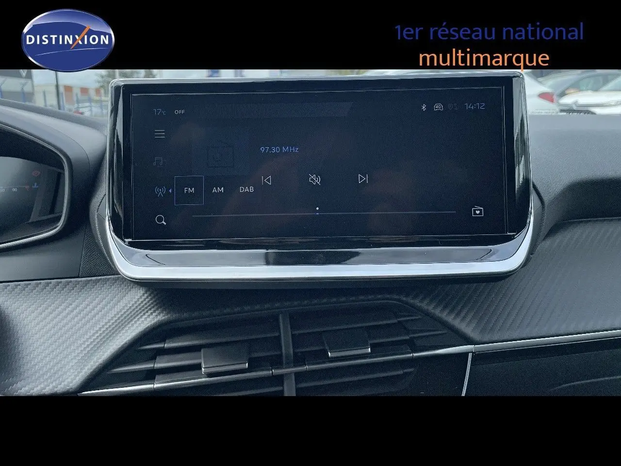 Écran tactile central du tableau de bord de la Peugeot 208 jaune Agueda Metal, affichant la radio FM à 97,30 MHz.