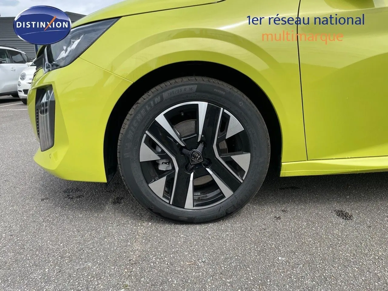Gros plan sur la roue avant gauche d'une Peugeot 208 jaune Agueda Metal avec jante noire et argentée.