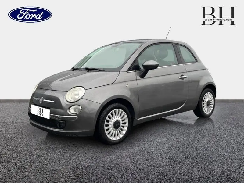 Vue 3/4 avant droite d'une FIAT 500 marron métallisé de 2010 avec jantes alu et toit ouvrant électrique.