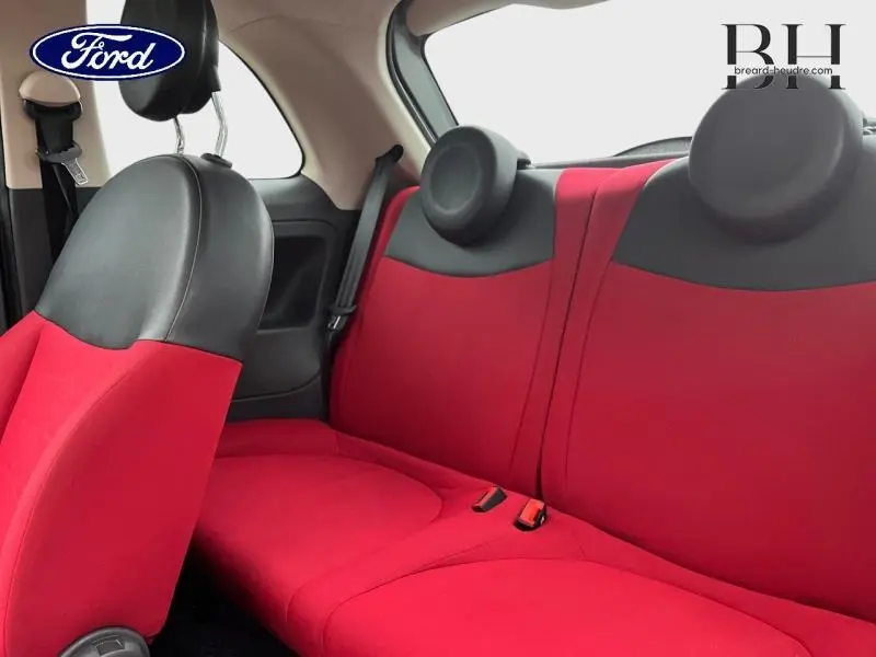 Vue intérieure arrière de la FIAT 500 avec sièges rouges et appuie-têtes ronds noirs, côté droit visible.