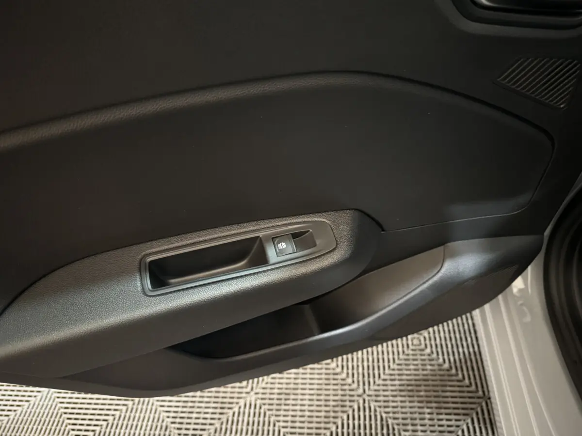 Gros plan sur la porte intérieure côté droit de la Renault Clio gris clair, avec commande de verrouillage des portes.