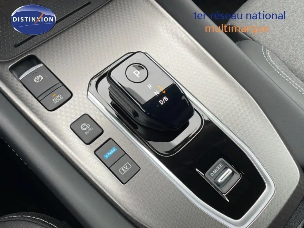 Gros plan sur la console centrale noire du Nissan Qashqai 2025 avec levier de boîte auto et commandes de modes de conduite.