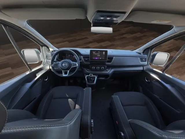Vue intérieure avant du Nissan Primastar 2025, tableau de bord moderne avec écran tactile central et volant multifonctions.