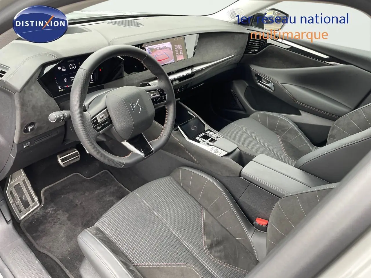 Vue intérieure côté conducteur du DS4 2024 gris laqué métal, avec volant multifonctions et sièges en cuir noir et alcantara.