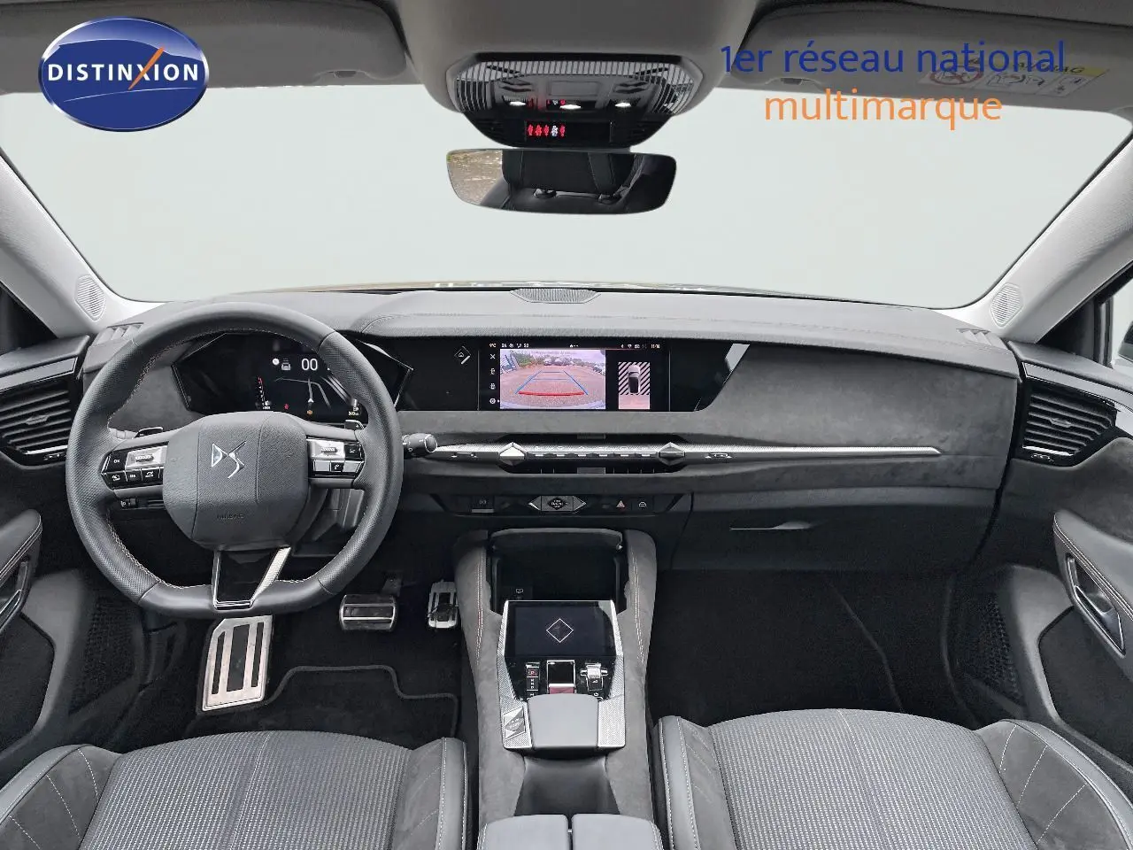 Intérieur du DS4 2024 en vue frontale, tableau de bord moderne avec écran central et volant multifonction noir.