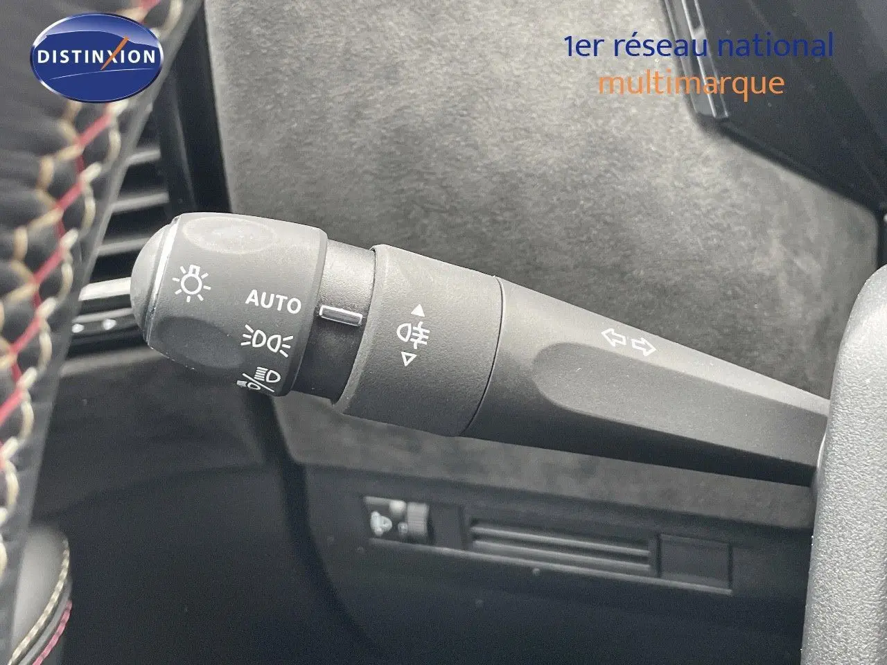 Le commodo d'éclairage et clignotant du DS4 2024 en gros plan avec volant cuir noir sur fond intérieur gris.