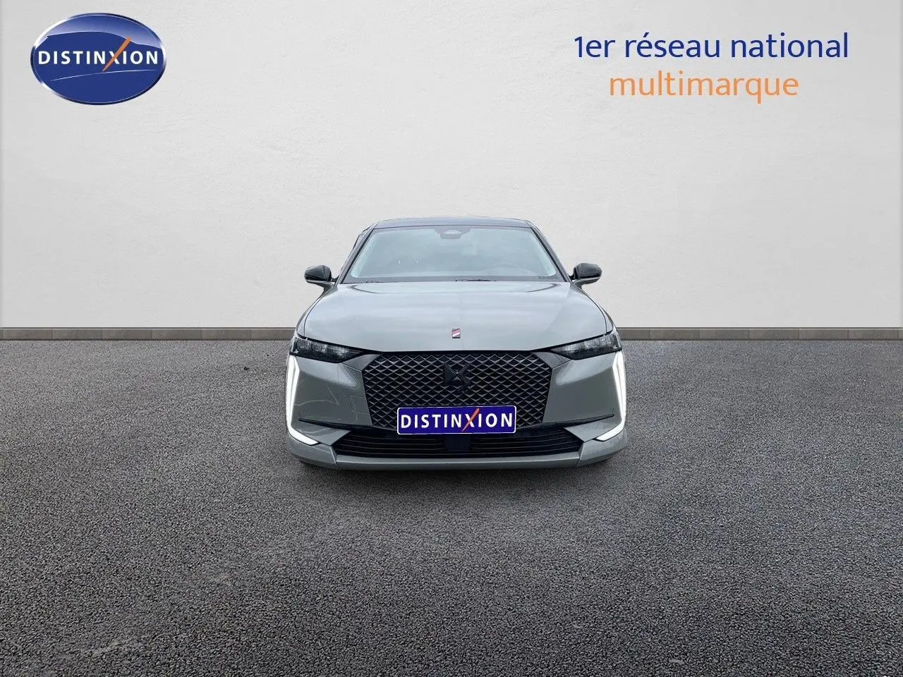 Vue frontale d'une DS4 gris laqué métal avec calandre noire et feux LED en forme de boomerang.