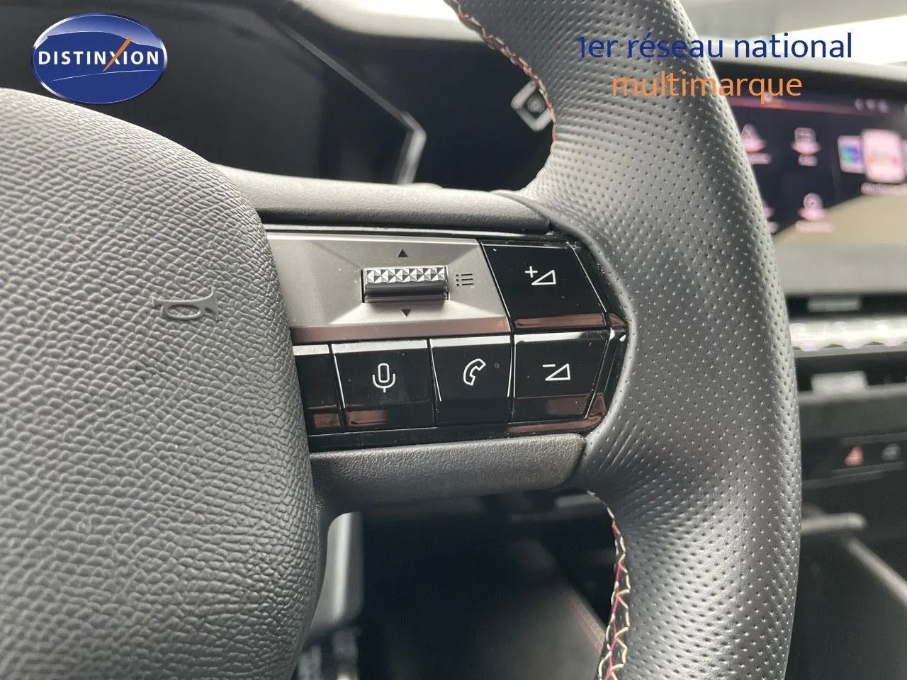 Gros plan sur les commandes du volant en cuir perforé d'une DS4 2024 gris laqué, mettant en valeur les boutons multifonctions.