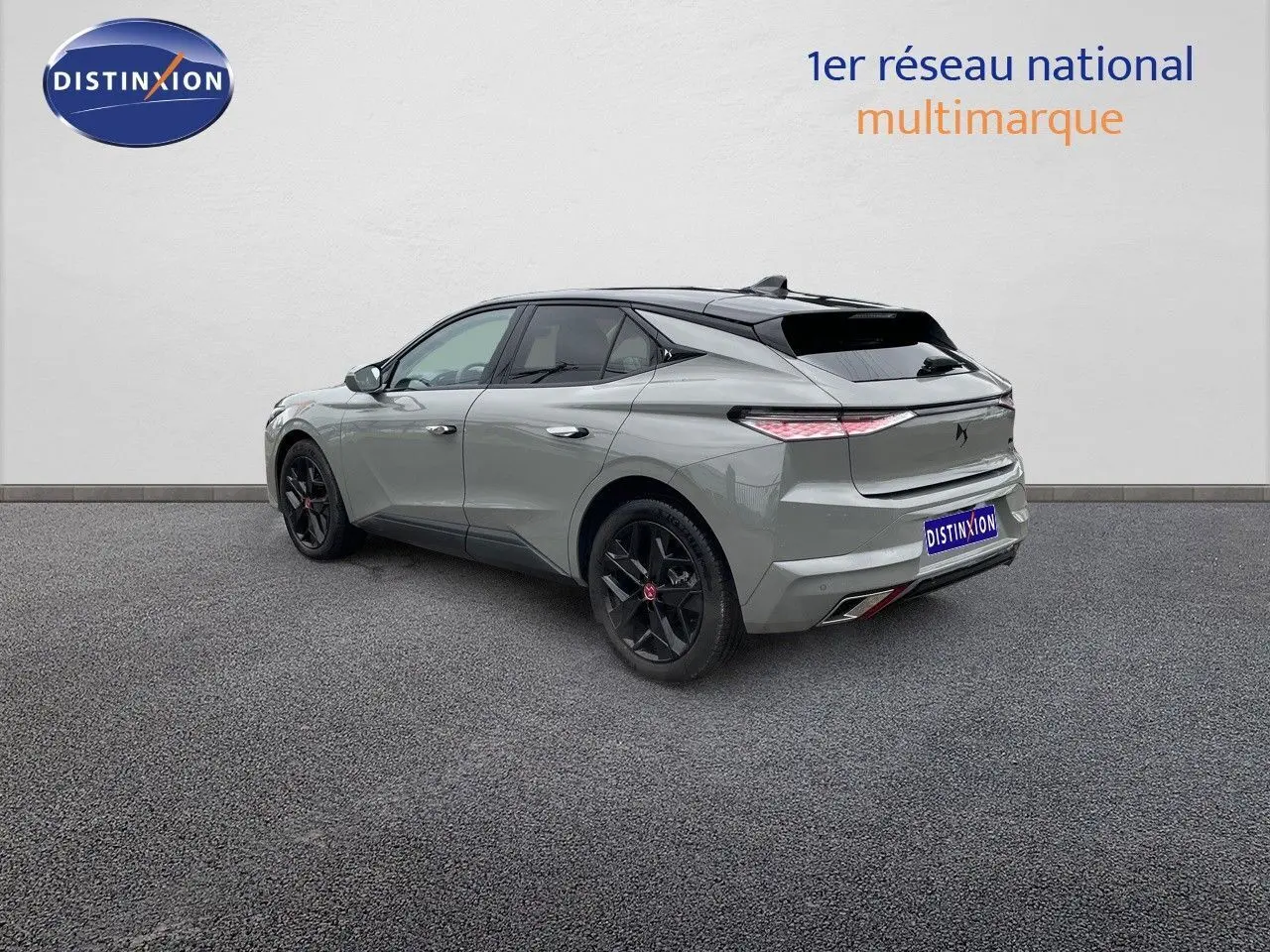 Vue 3/4 arrière droite d'une DS4 2024 gris laqué métal avec jantes noires et feux arrière effilés.