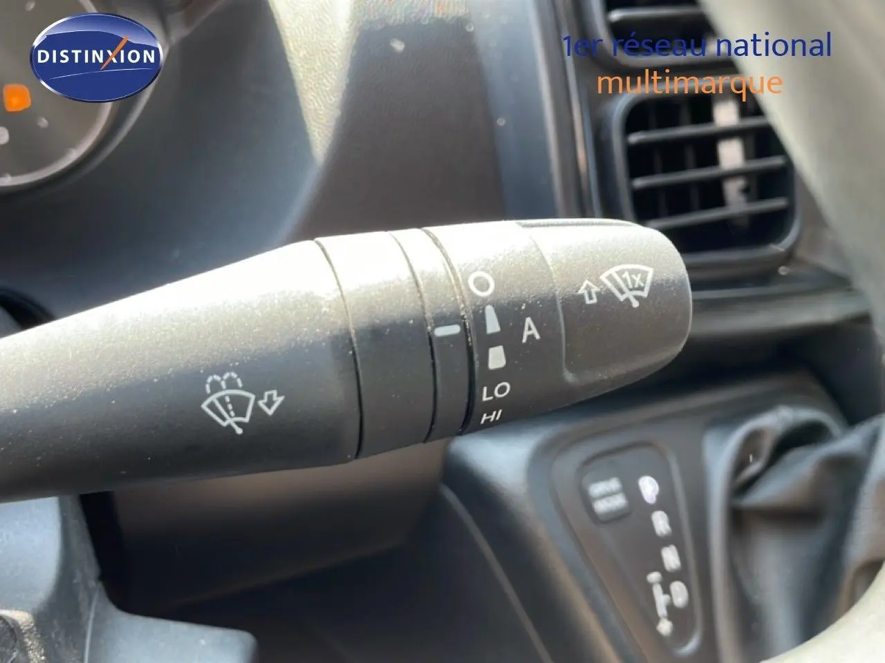 Gros plan sur la commande d’essuie-glace à gauche du volant dans l’habitacle du Peugeot Boxer blanc banquise.