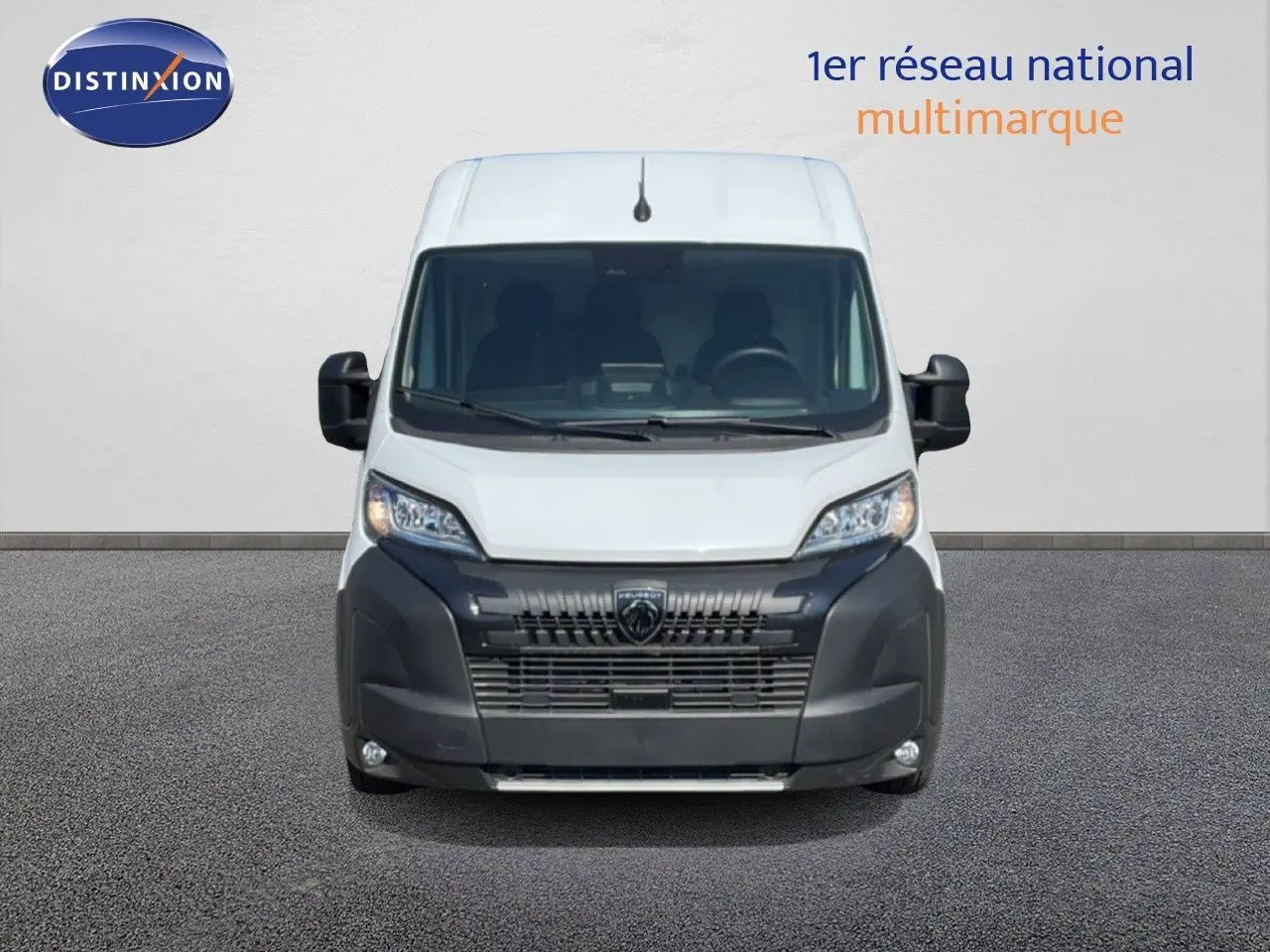 Vue de face du Peugeot Boxer Fourgon blanc banquise avec calandre noire et phares allumés sur fond neutre.