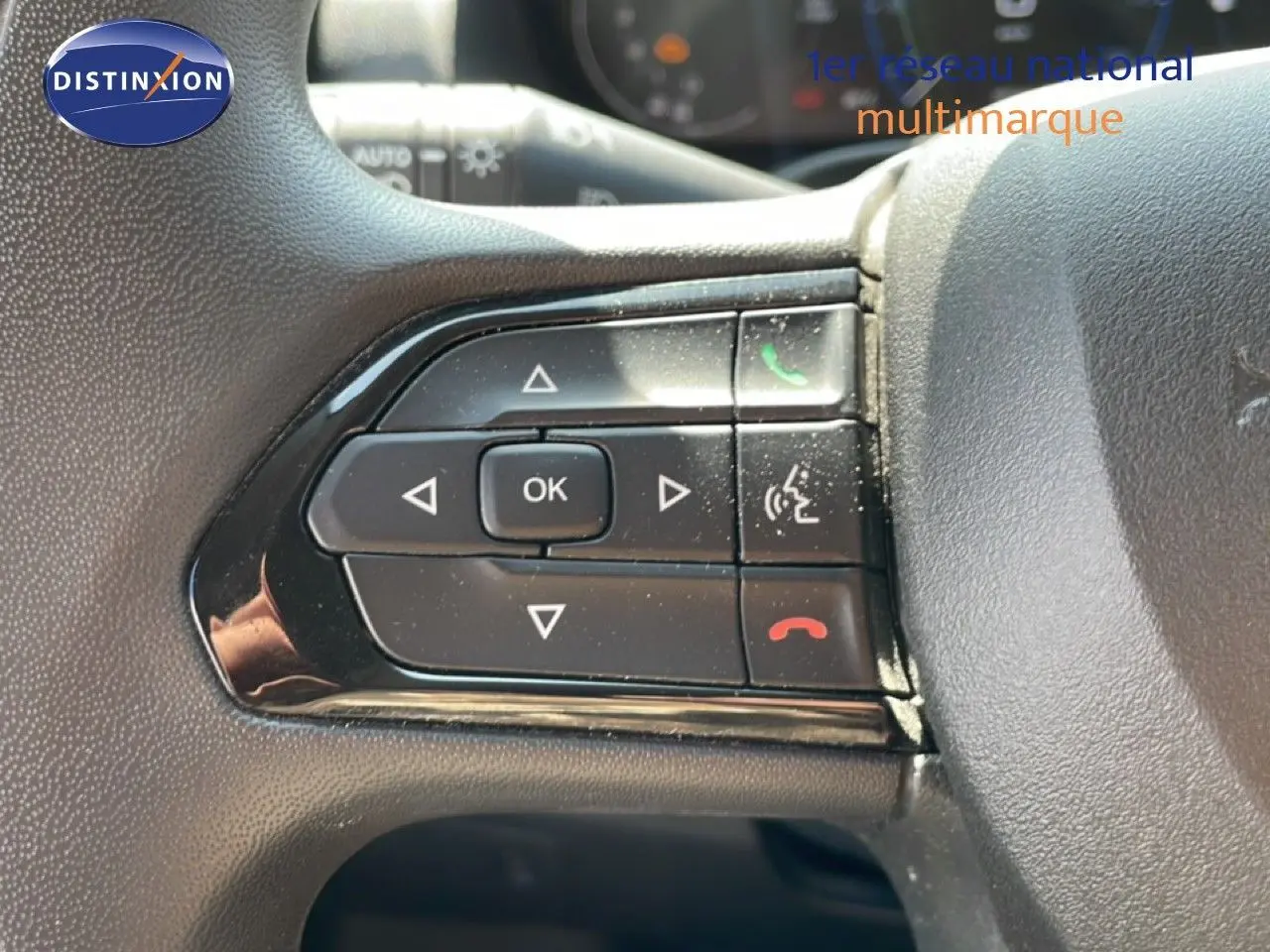 Gros plan sur les commandes au volant du Peugeot Boxer Fourgon blanc banquise, avec boutons de gestion d'appel et navigation.