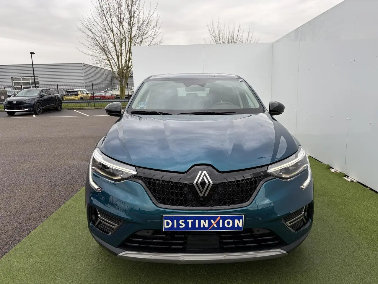 Vue frontale d'un Renault Arkana 2025 bleu Zanzibar métal avec calandre noire et phares LED distinctifs.