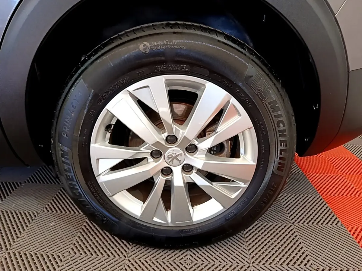 Gros plan sur la roue avant droite gris clair du Peugeot 5008 avec jante alliage et pneu Michelin.