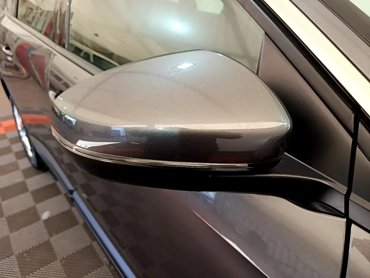 Rétroviseur électrique rabattable gris clair du côté gauche d’un Peugeot 5008, vue rapprochée en intérieur.