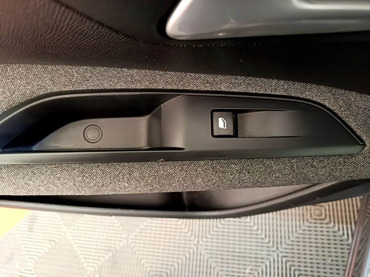 Gros plan sur la commande de lève-vitre côté porte intérieure avec revêtement tissu gris du Peugeot 5008 gris clair.