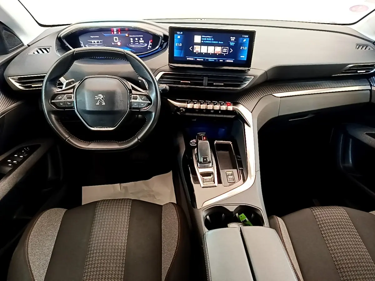 Vue intérieure avant du Peugeot 5008 2021, tableau de bord moderne avec écran tactile et volant cuir multifonctions.