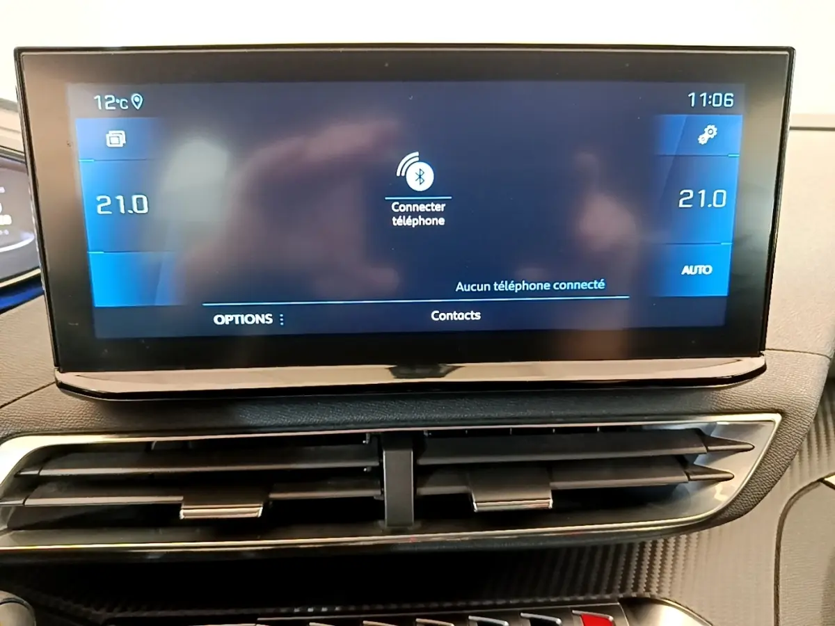 Écran tactile central bleu affichant la connexion Bluetooth, avec les aérateurs noirs en dessous, intérieur Peugeot 5008 gris clair.