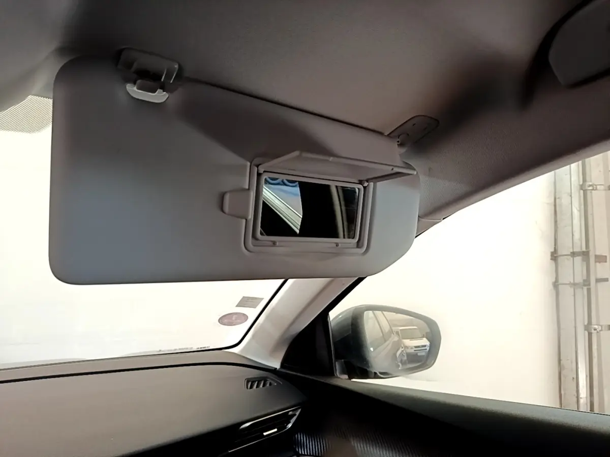 Intérieur du Peugeot 5008 gris clair vu côté passager, avec pare-soleil rabattable et miroir intégré.