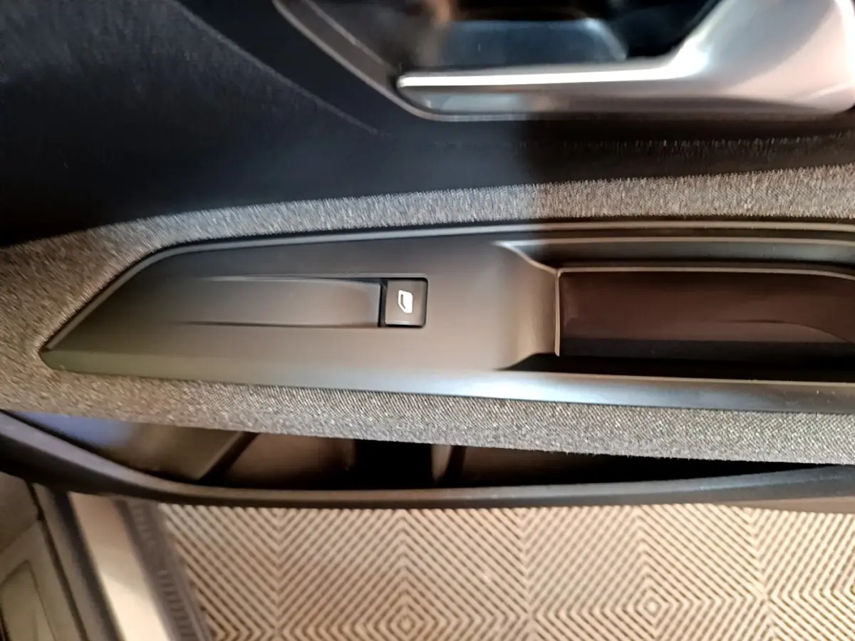 Gros plan sur la commande de lève-vitre côté conducteur dans l’habitacle gris du Peugeot 5008 2021.