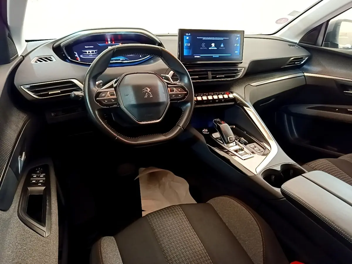 Vue intérieure avant du Peugeot 5008 2021, tableau de bord moderne avec écran tactile central et volant cuir multifonctions.