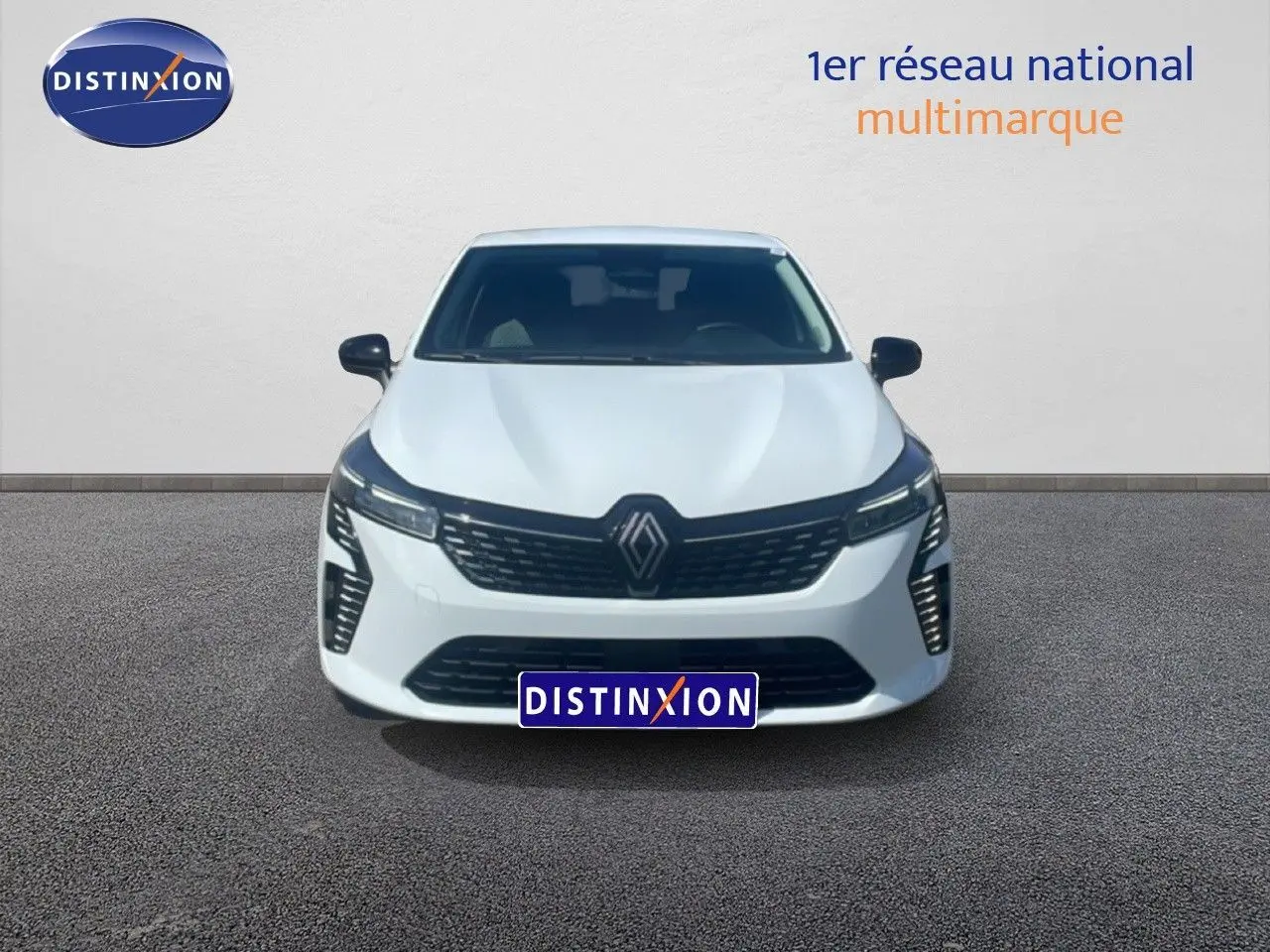 Vue de face d'une Renault Clio blanche 2025 avec calandre noire et phares LED distinctifs sur fond neutre.