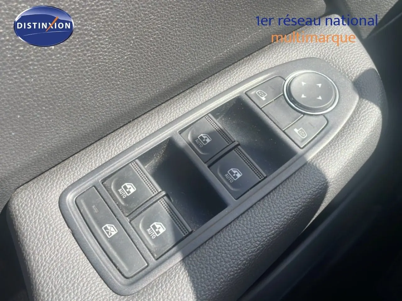 Commande des vitres électriques et réglage des rétroviseurs sur la portière côté gauche d'une Renault Clio blanche.
