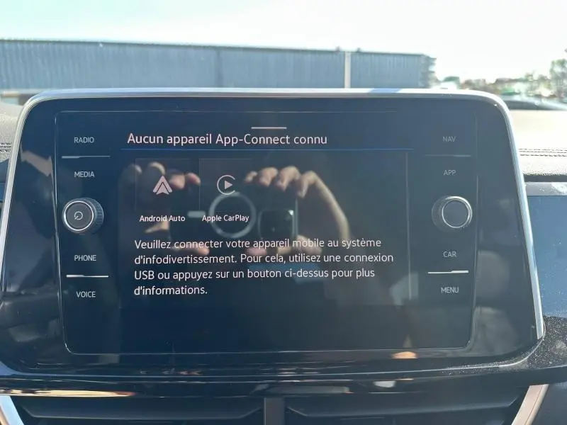 Vue rapprochée de l’écran tactile central du Volkswagen T-Roc noir intense nacré, affichant un message de connexion App-Connect.