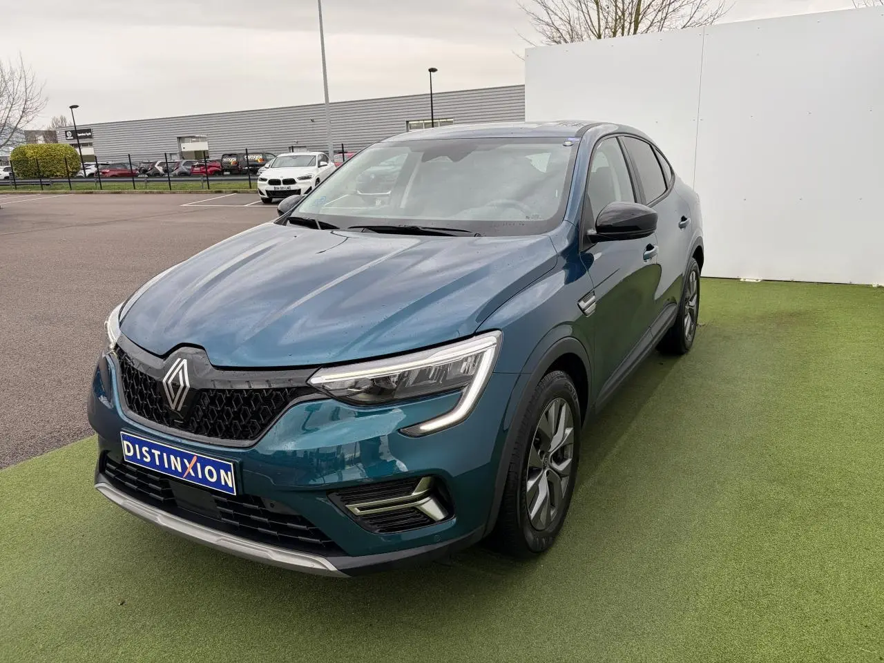 Vue 3/4 avant droite d’un Renault Arkana bleu Zanzibar métallisé avec calandre noire et jantes alliage grises 17 pouces.