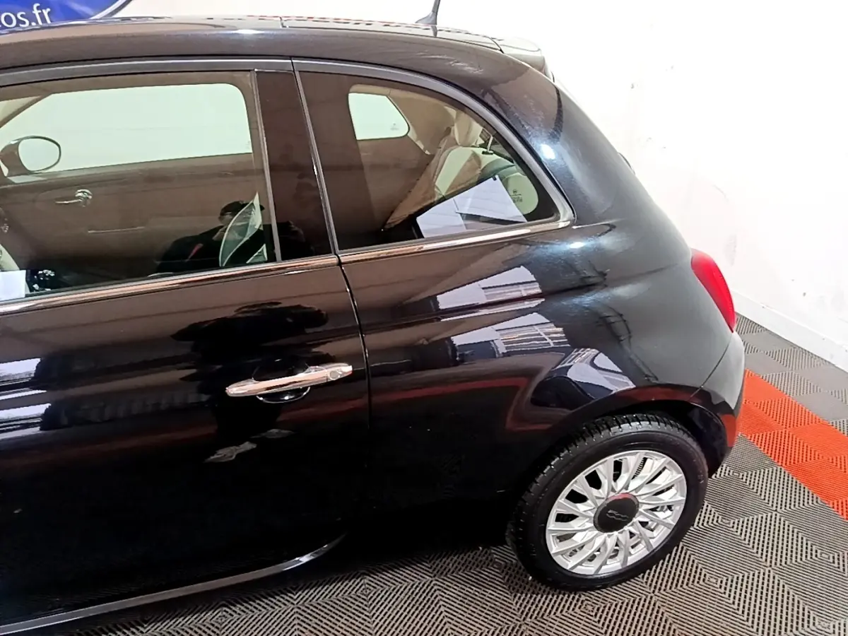 Vue côté droit arrière d'une FIAT 500 noire 2019 avec jante alliage et poignée de porte chromée.