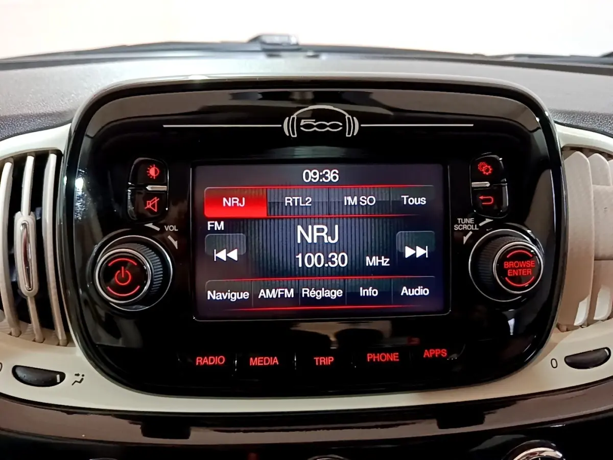 Écran tactile central noir affichant la radio NRJ à 100.30 MHz dans l’habitacle beige d’une Fiat 500 Lounge 2019.