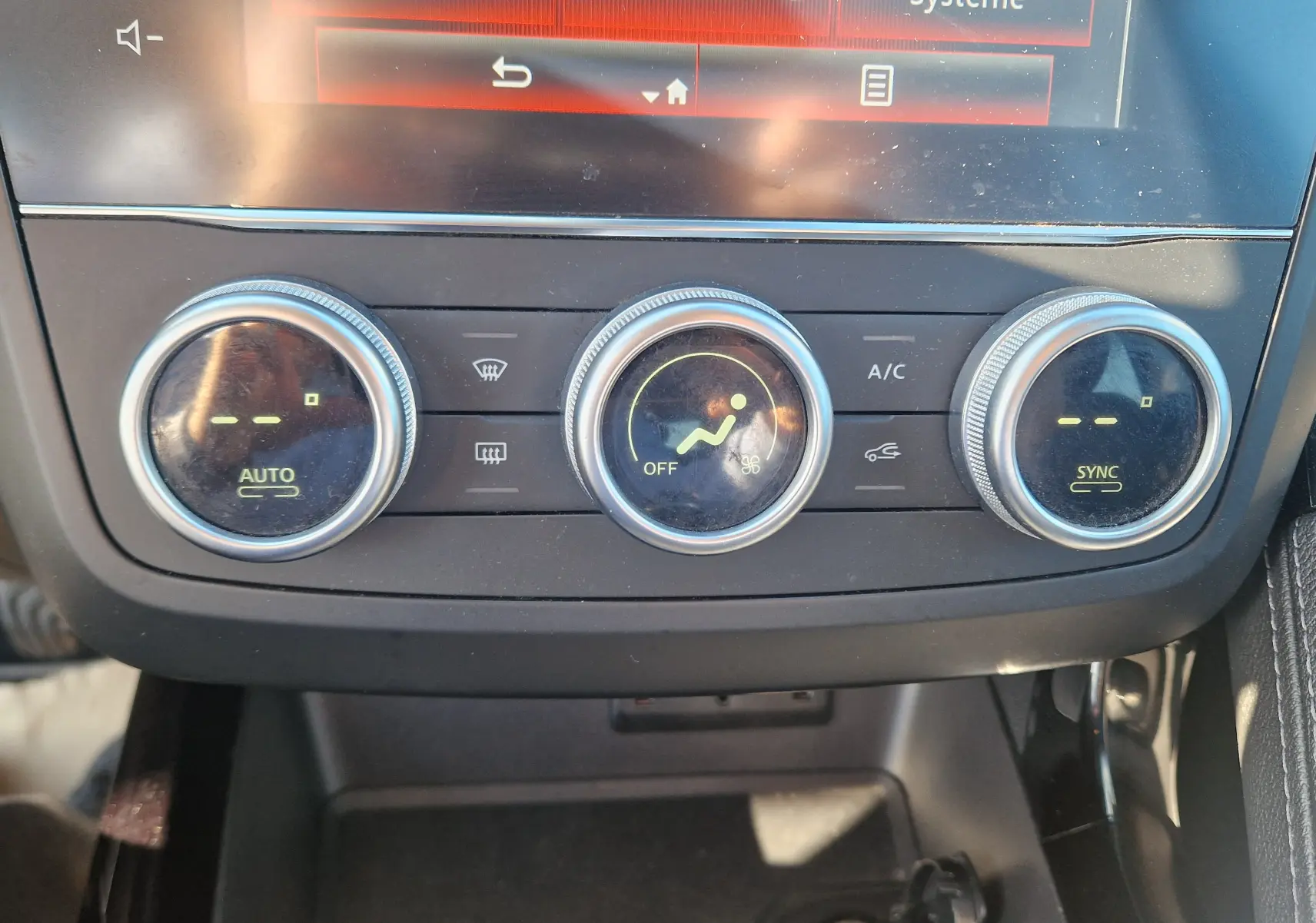 Gros plan sur les commandes de climatisation automatique du Renault Kadjar 1.5 Blue dCi 115 Business, tableau de bord noir.