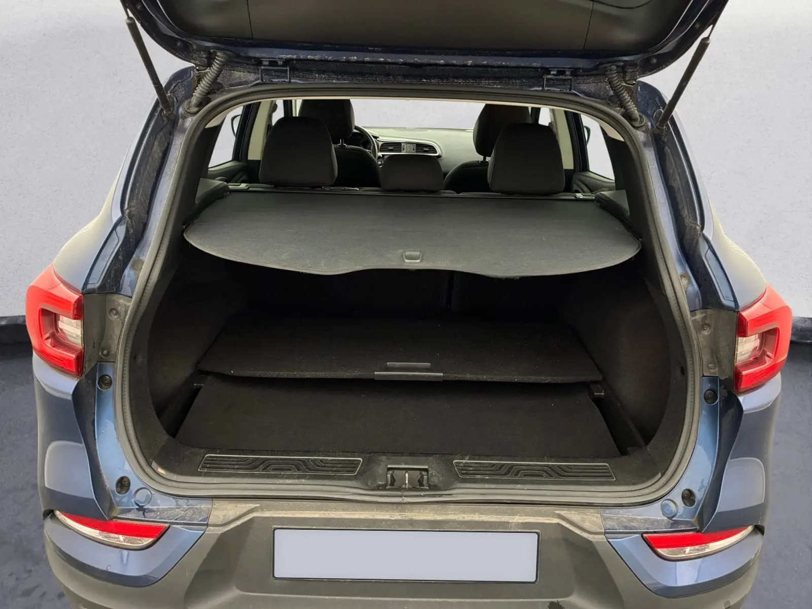 Vue intérieure côté droit des sièges arrière en tissu noir du Renault Kadjar bleu cosmos, porte arrière ouverte.