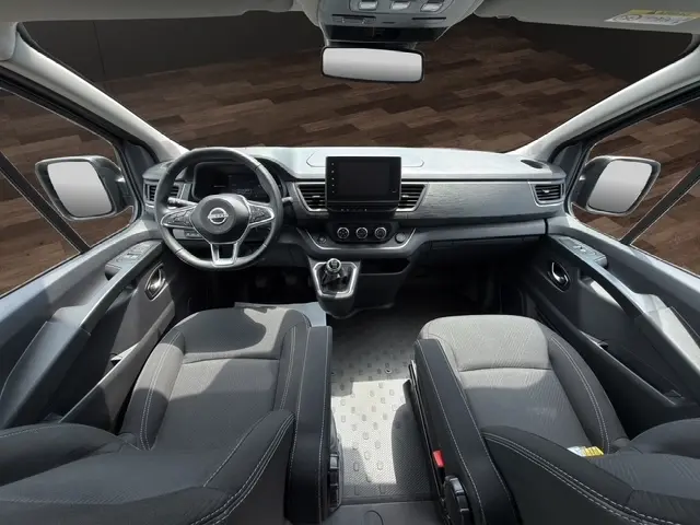 Vue intérieure avant du Nissan Primastar 2025 noir, avec tableau de bord moderne et écran tactile central.