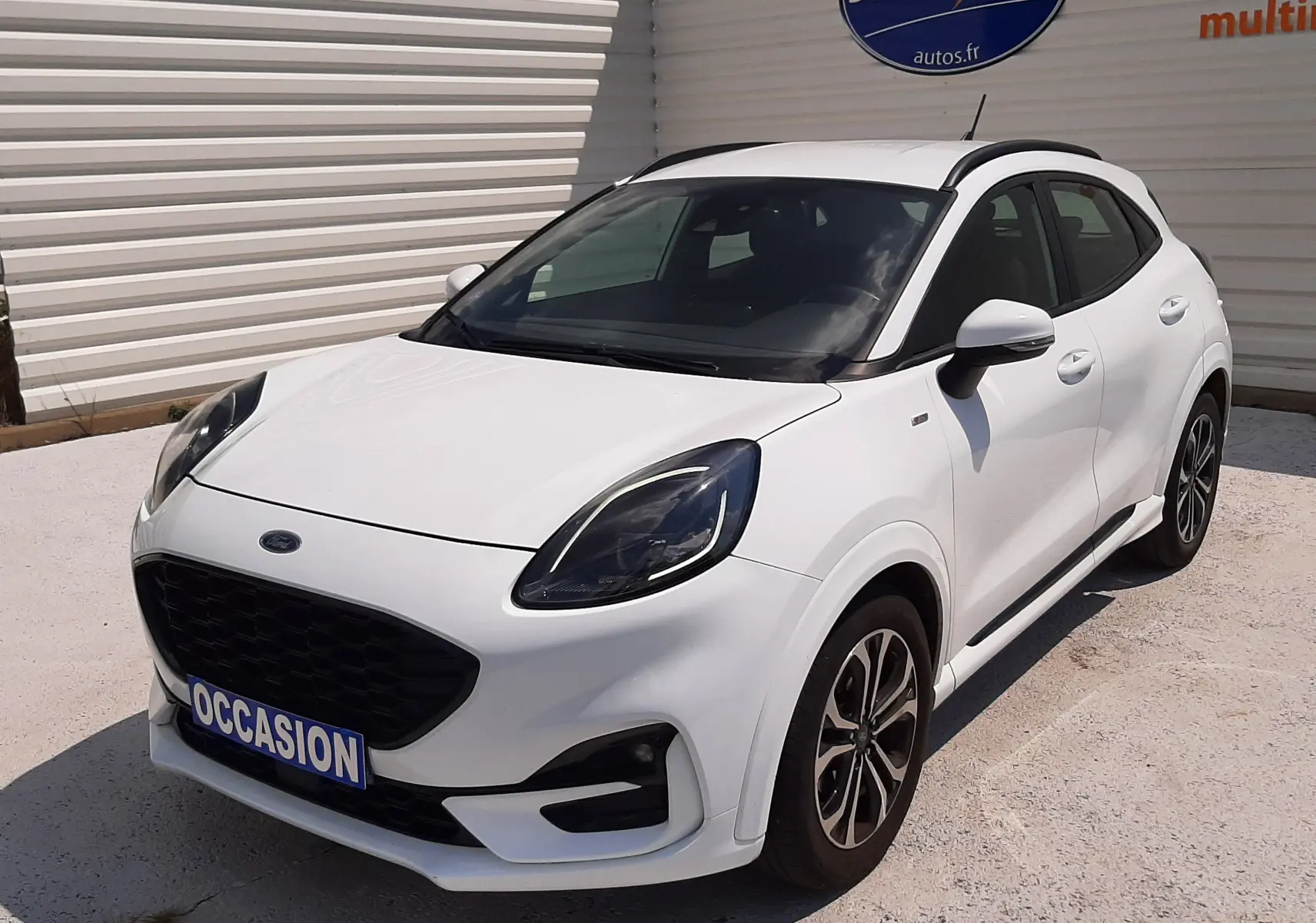Vue 3/4 avant droite d'une Ford Puma blanche 2022 finition ST-Line avec calandre noire et jantes alliage bicolores.