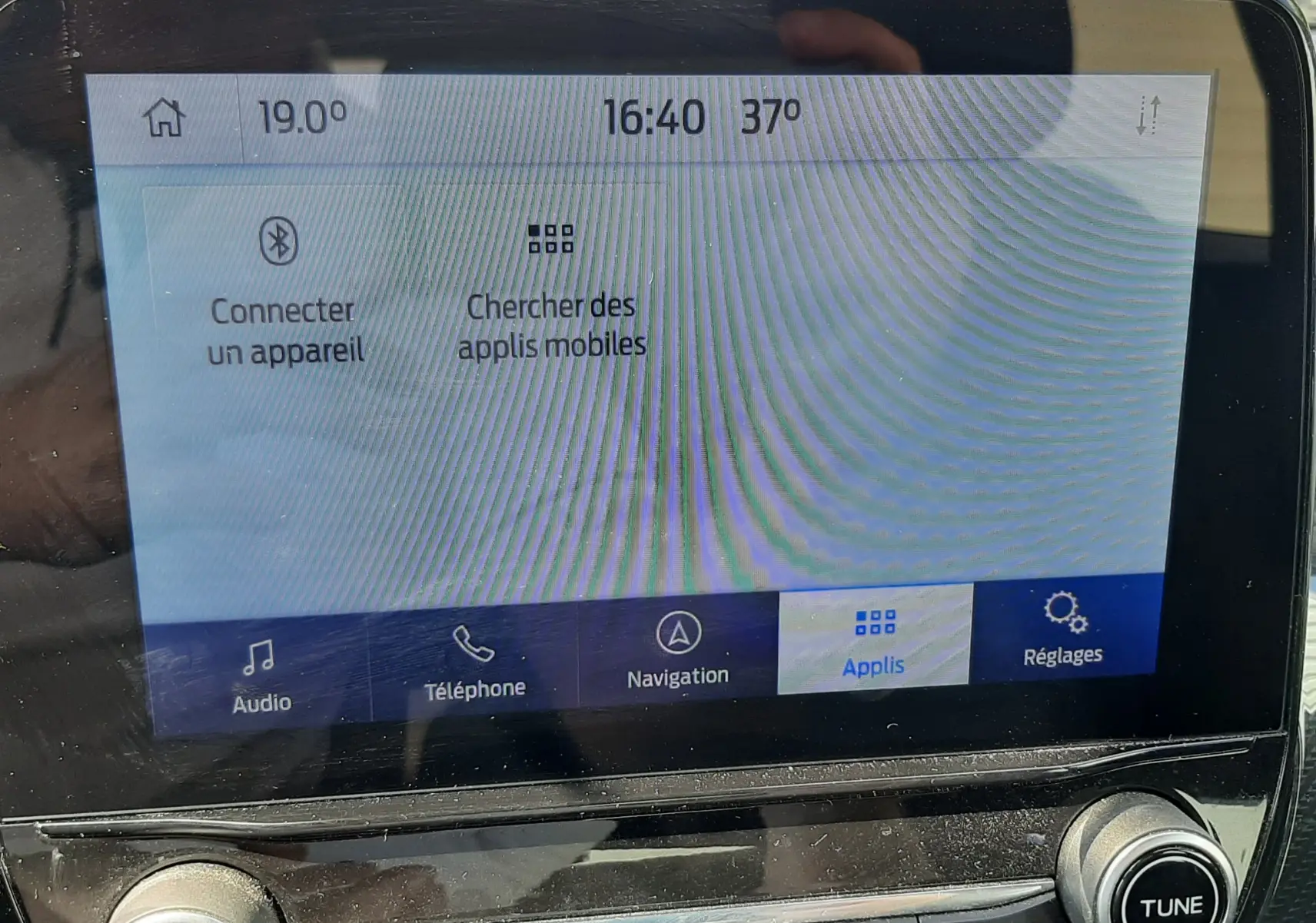 Écran tactile central du Ford Puma blanc 2022, affichant le menu applications avec commandes audio et navigation.