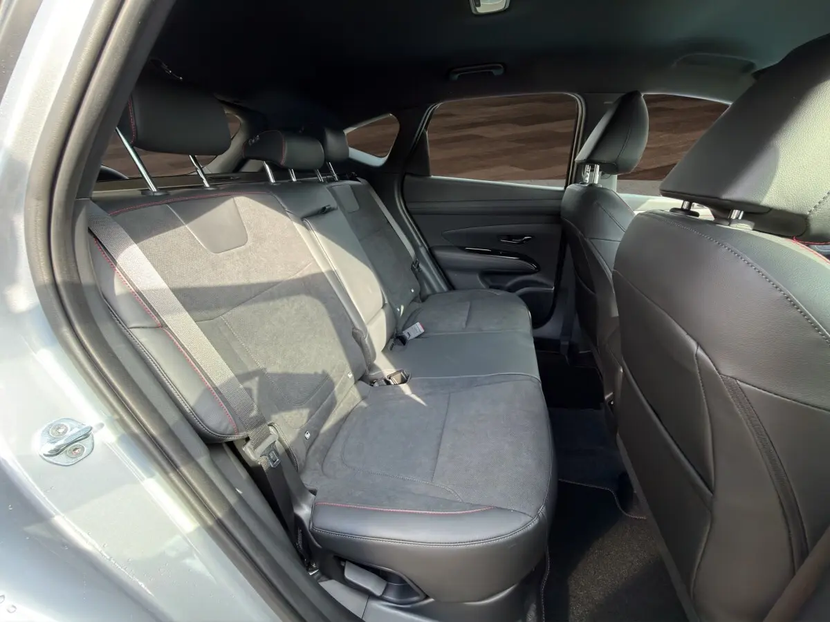 Vue intérieure côté gauche des sièges arrière en cuir noir et tissu gris du Hyundai Tucson 1.6 Hybrid gris clair 2026.