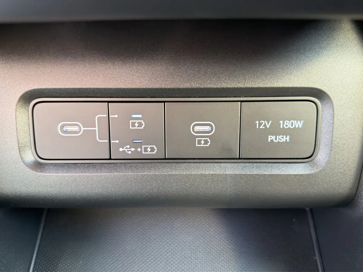 Gros plan sur les ports USB-C et prise 12V 180W du tableau de bord du Hyundai Tucson gris clair 2026.