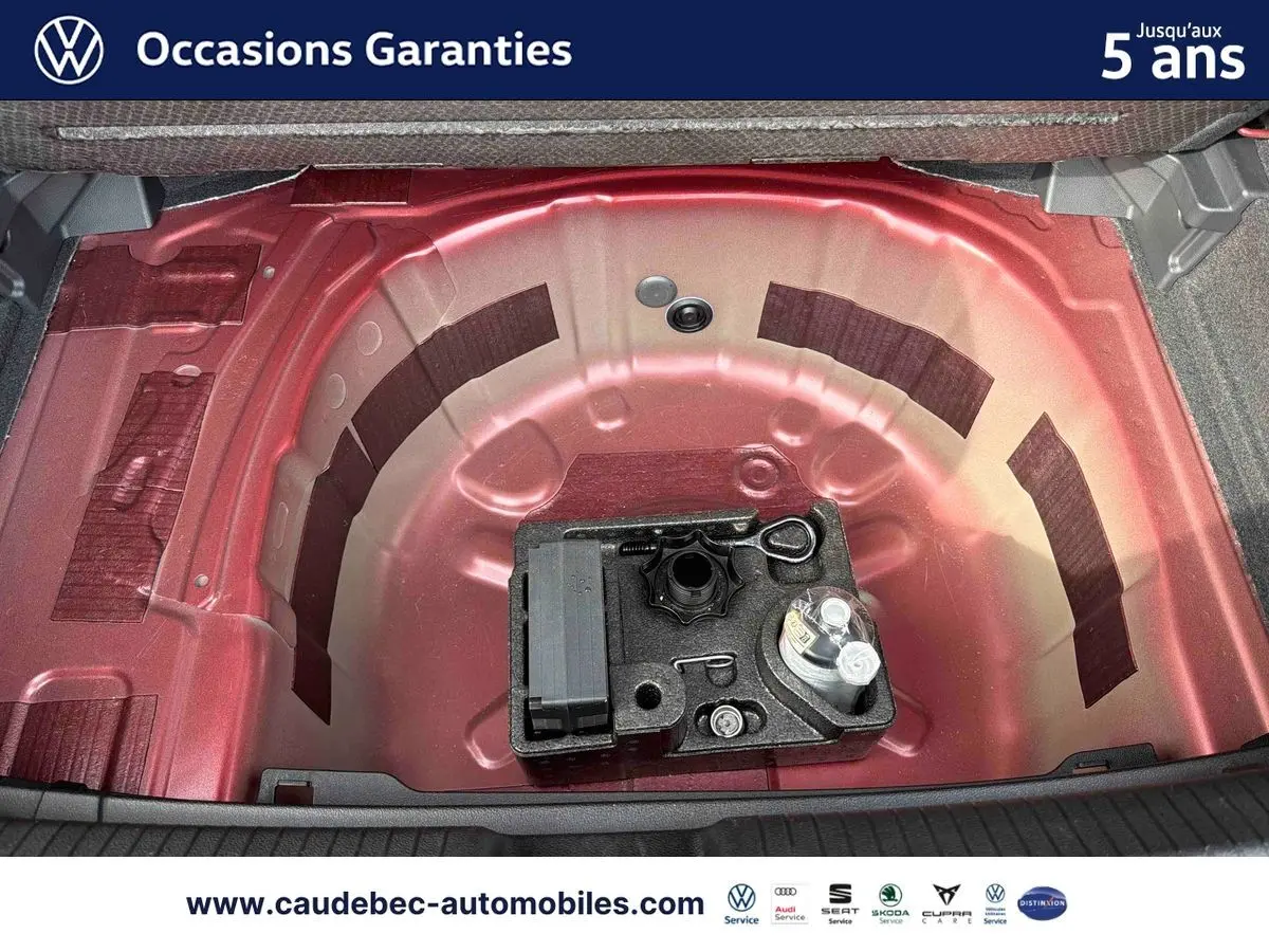 Coffre ouvert montrant la roue de secours et l'espace de rangement rouge de la Volkswagen Polo 2025.
