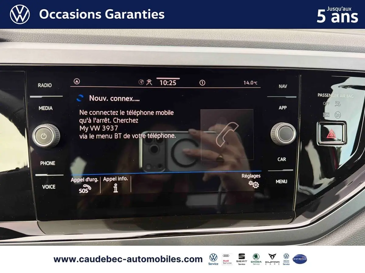 Vue rapprochée de l’écran tactile multimédia noir du Volkswagen Polo rouge, affichant la connexion Bluetooth active.
