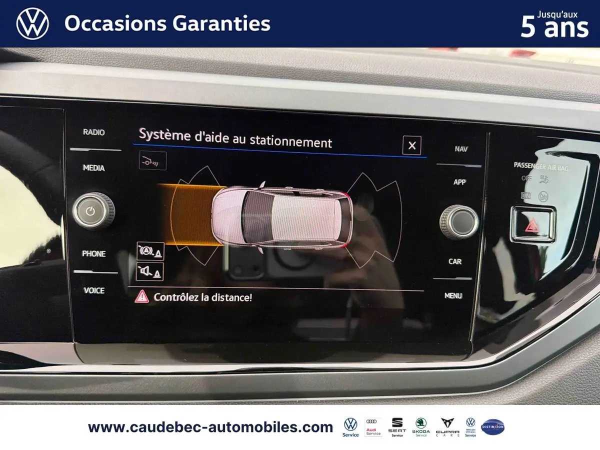 Écran tactile intérieur de la Volkswagen Polo rouge montrant le système d'aide au stationnement en vue du dessus.