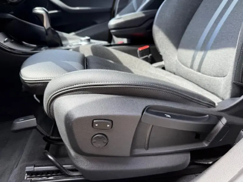 Gros plan sur le réglage électrique du siège avant gauche en tissu gris du BMW X2 xDrive25eA 2021 Galvanic Gold.