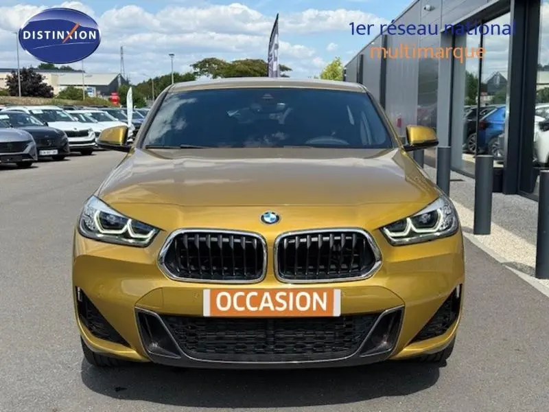 Vue frontale d'un BMW X2 xDrive25eA 220ch M Sport 2021 en Galvanic Gold métallisé avec calandre noire distinctive.