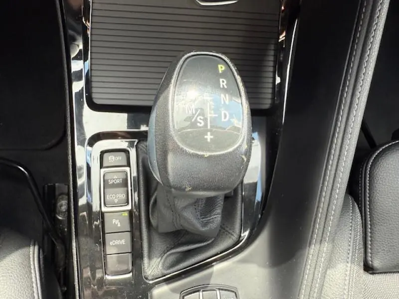 Le levier de vitesses automatique et les boutons de mode de conduite dans l'habitacle d'une BMW X2 Galvanic Gold.