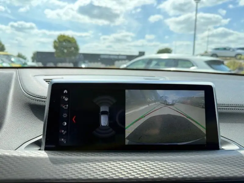 Écran central du BMW X2 xDrive25e 2021 montrant la caméra de recul avec lignes de guidage en stationnement.
