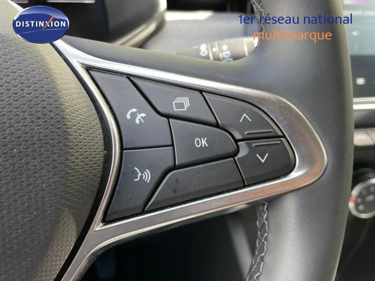 Gros plan sur les commandes multifonctions côté gauche du volant cuir d’une Renault Clio gris schiste 2025.