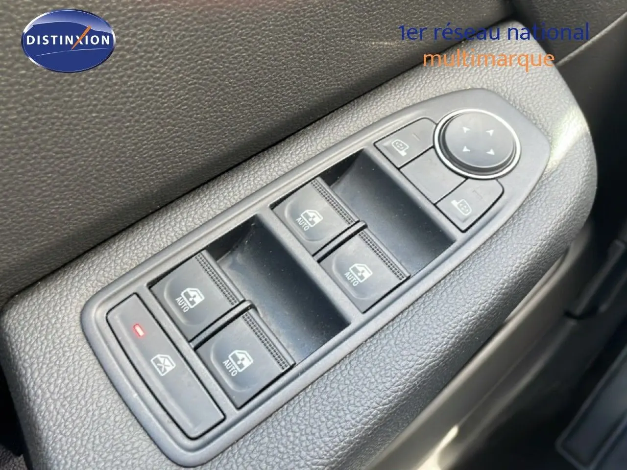 Gros plan sur les commandes de lève-vitres et rétroviseurs côté gauche d’une Renault Clio gris schiste métal 2025.