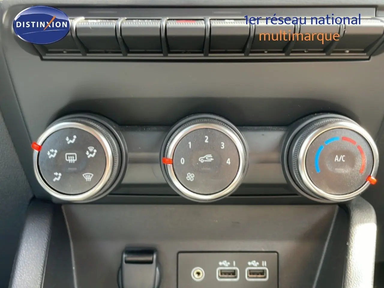 Gros plan sur les commandes de climatisation et les ports USB de la Renault Clio gris schiste métal, version 2025.