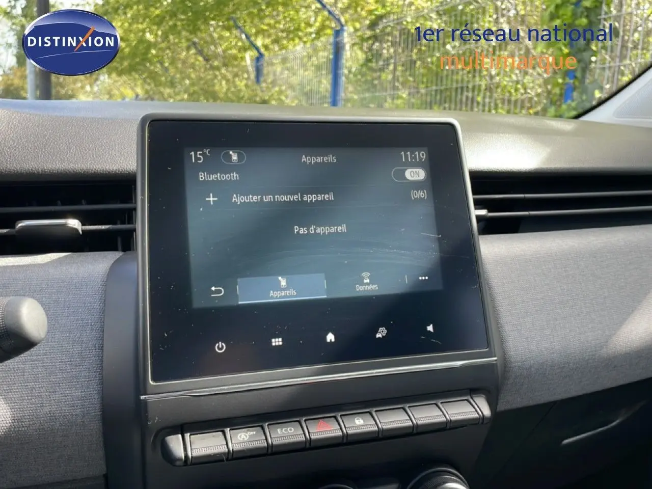 Tableau de bord de Renault Clio 2025 avec écran tactile central et commandes sous l'écran, ambiance intérieure grise.